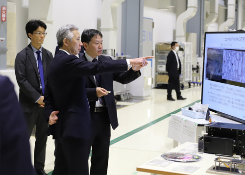 SPring-8蓄積リング棟実験ホールで矢橋 グループディレクターから説明を受けられる盛山 大臣の写真