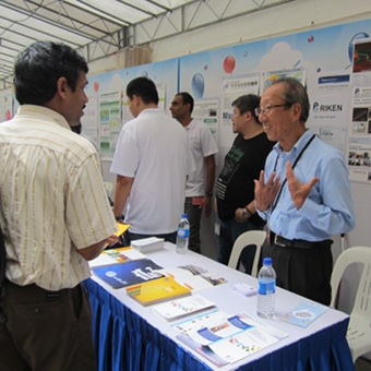 Talking with visitors at the RIKEN booth