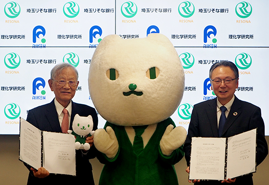 覚書を手にする松本紘理事長（左）、池田一義代表取締役社長（右）、中央はりそなグループのコミュニケーションキャラクターりそにゃの写真