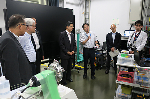 放射光科学研究センターの矢橋牧名グループディレクターから説明を受ける石井大臣（SACLA　実験研究棟にて）の写真
