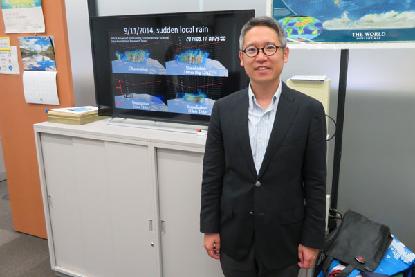 Picture of Takemasa Miyoshi in front of the screen showing the rain prediction