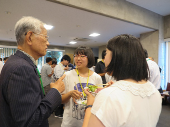 松本理事長と高校生たちの画像