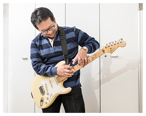 ギターを弾く田中主任研究員の写真