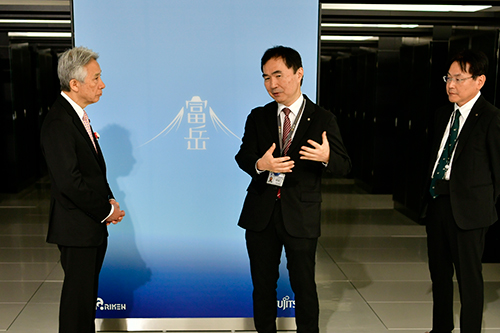 計算機室で「富岳」実機を前に松岡 センター長、松尾 理事から説明を受けられる盛山 大臣写真