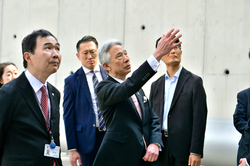 熱源機械棟屋外施設の冷却設備について説明を受けられる盛山 大臣の写真