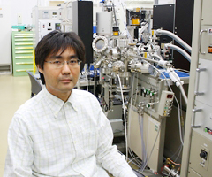 松野 丈夫 専任研究員とパルスレーザー堆積法薄膜合成装置の写真