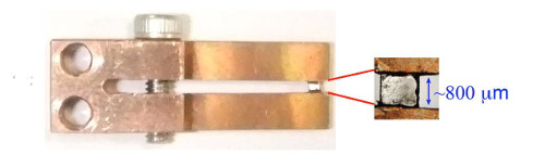 The sample squeezed between copper tongs