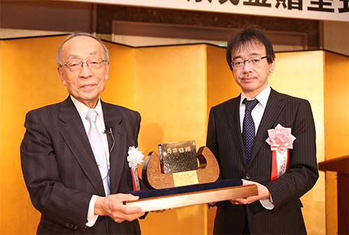 宮脇敦史 副センター長が賞牌を受け取っている様子