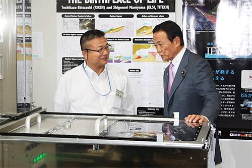 戎崎俊一主任研究員と麻生太郎(あそう たろう)副総理・財務大臣の様子