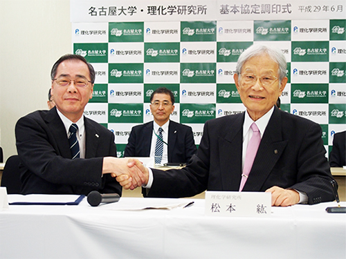 調印後握手を交わす松尾総長(左)と松本理事長(右)の写真