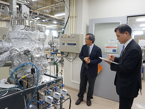 写真：実験室にて十倉センター長（左）から説明を受けられる柴山大臣