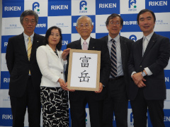 Picture of RIKEN executives holding up the name