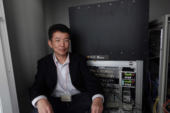 Photo showing Hidetoshi Katori with a clock